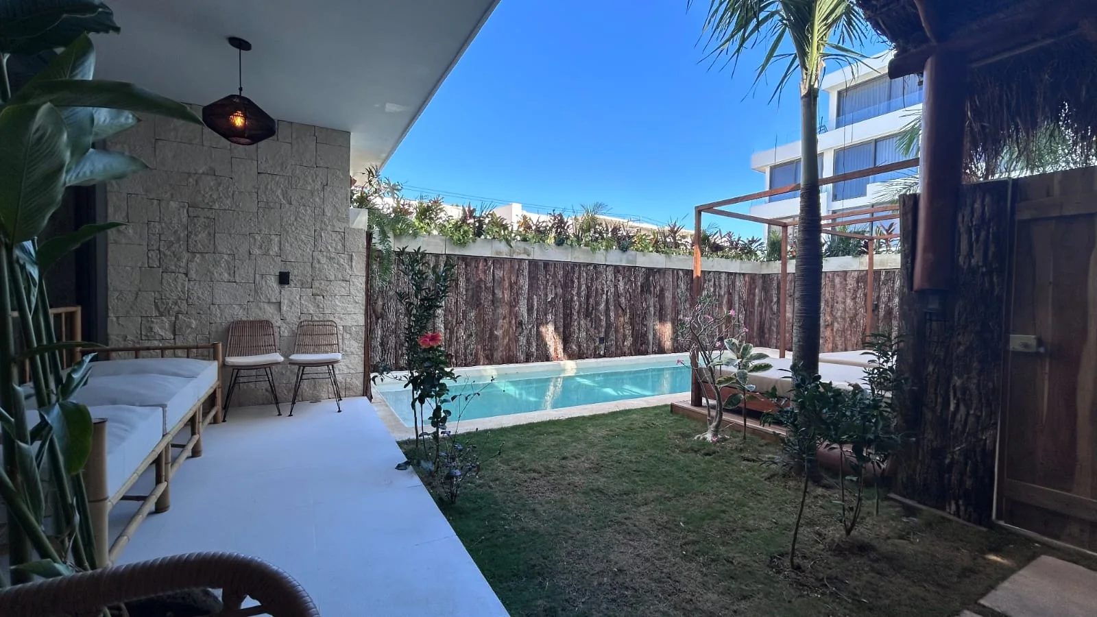 Patio con jardín y alberca en un departamento en venta en La Veleta, Tulum