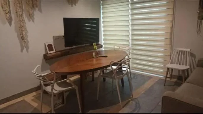 Sala y comedor equipados con detalles de fibras naturales en un departamento en renta en Tulum